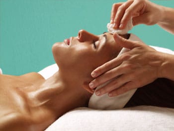 woman laying down with towel around head undergoing med spa facial