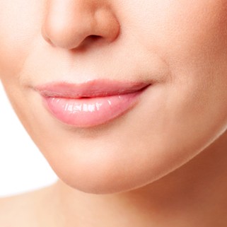 close up of woman's mouth with slight smile and white background