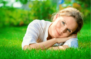 smiling woman lying on a grass outdoor.