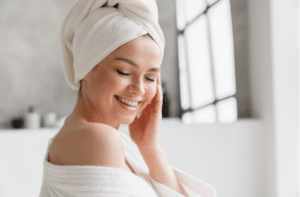 Calm serene young woman in bathrobe and towel relaxing after taking bath