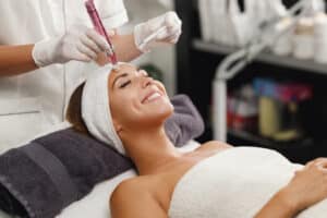 Woman looking in the mirror after a ClearSilk laser facial